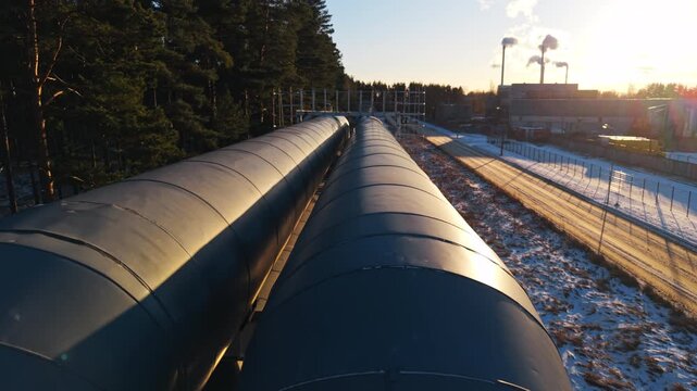 Parallel pipes near train tracks, Aerial view of parallel pipelines during sunset near station