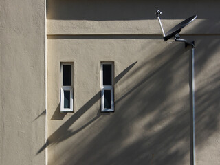 Beige colour wall with rectangular frame aluminium glass awning window and a dish antenna.