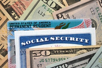 Social security number and permanent resident card with US dollar money bills close up