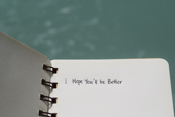 A simple, aesthetic spiral notebook with the handwritten quote 