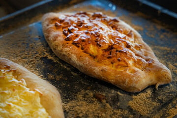 Freshly baked bread with melted cheese and golden crust on a rustic baking tray