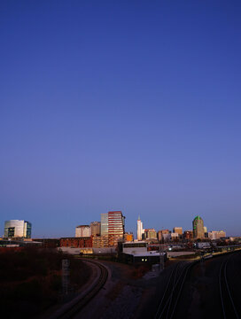 The downtown Raleigh skyline and railroad tracks at sunset