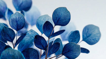 Artistic representation of delicate blue leaves with intricate vein patterns on thin stems creating a visually striking and elegant natural design against a light ba