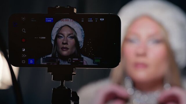 Woman filming beauty tutorial nearby, Studio shot featuring woman filming beauty content with equipment