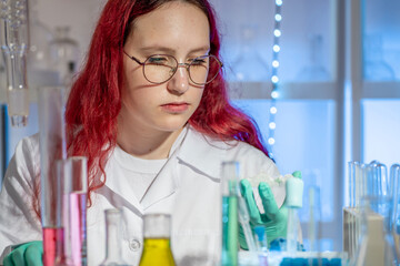 Teenage girl performing a chemistry experiment during a modern school laboratory lesson. Practical science education concept with hands-on learning, contemporary classroom and STEM teaching approach.