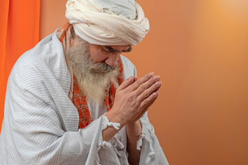 Senior man in a turban is associated with a Hindu, Jain, Buddhist.  Prayer gesture.