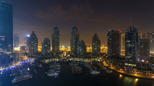 Dubai Marina all night timelapse, Glittering lights and tallest skyscrapers during a clear evening - Powered by Adobe