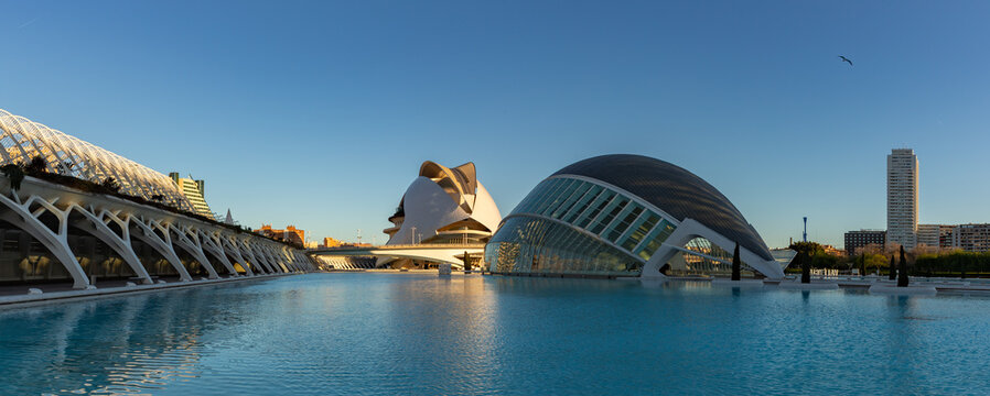 Valencia, Spain - March 30, 2025: A picture of the City of Arts and Sciences at sunrise, with the Hemisferic, the Queen Sofia Palace of Arts and the L'Umbracle on display.