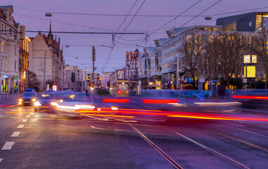 city traffic with light trails in twilight in winter, long exposure wide angle scene in downtown district Magdeburg, Germany