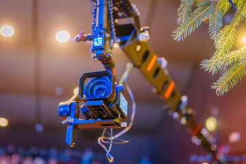 Professional camera mounted on a crane, capturing dynamic shots in a studio setting, surrounded by soft lighting and festive decorations, showcasing advanced filming technology