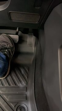 Man working on a car, pressing the brake pedal
