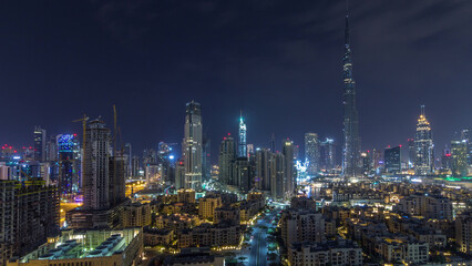 Naklejka premium Dubai Downtown skyline during all night timelapse with Burj Khalifa and other towers panoramic view from the top in Dubai