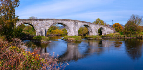 Fototapeta premium Stirling Old Bridge, also known as the Battle of Stirling Bridge, spanning the River Forth in the United Kingdom, a tranquil landmark of historic stone architecture in Scotland