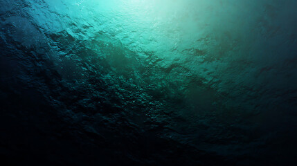 Deep underwater ocean texture with teal light filtering from surface creating mysterious aquatic backdrop ideal for environmental themes exploration and abstract backgrounds