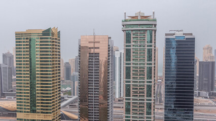 Fototapeta premium Residential and office buildings in Jumeirah lake towers district night to day timelapse in Dubai