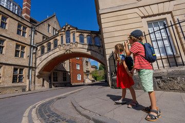 Kids explore a historical archway Bridge of Sighs, Oxford, UK