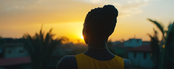 Woman watches sunset, city backdrop, peaceful evening