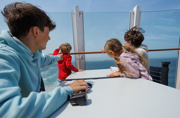 Family seated, captivated by ocean views on a sunny day at deck