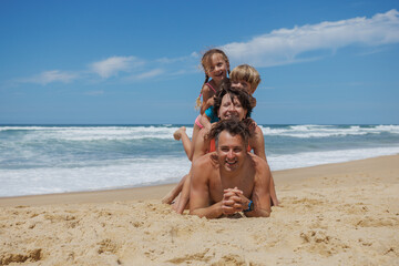 Family fun at the beach, stacked on each other in laughter