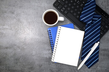 Necktie with notebook and keyboard on stone texture background. Business desk office. Top view