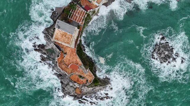 Aerial view of the vibrant Erchie beach with its historic coastal tower, set against the turquoise sea and rocky cliffs, Erchie, Amalfi Coast, Italy.