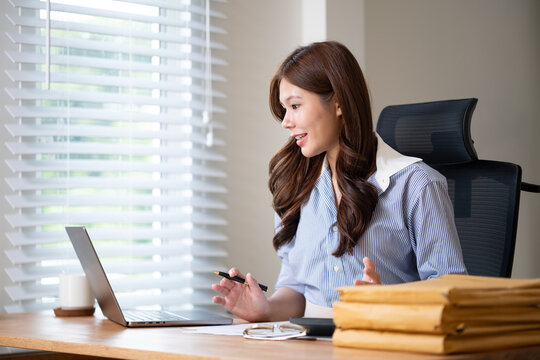 Young businesswoman having a virtual meeting from her office desk. - Powered by Adobe
