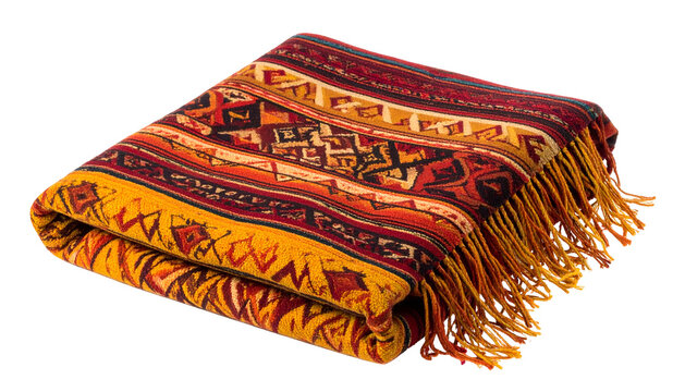 A folded blanket with a vibrant woven pattern and long fringe against a black backdrop