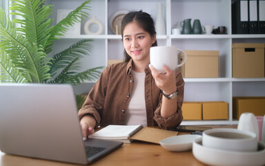 Young woman working remotely while enjoying a hot drink during a video call.