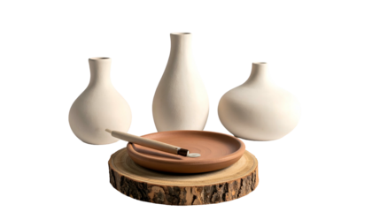 Still life of minimalist ceramic vases, plate, and tool, on a wooden base
