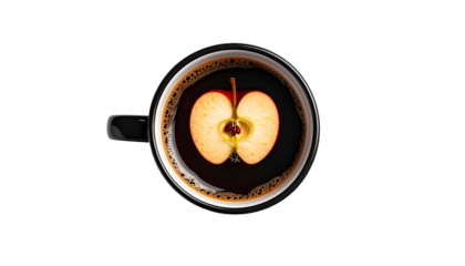 Overhead view of a black mug filled with dark liquid, cradling a halved red apple