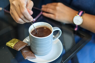 A serving of hot chocolate drink accompanied by a chocolate bar.