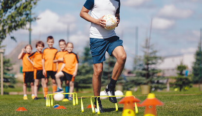 Youth Soccer Training Session With Coach &ndash; Kids Practicing Football Drills and Agility Exercises Outdoors