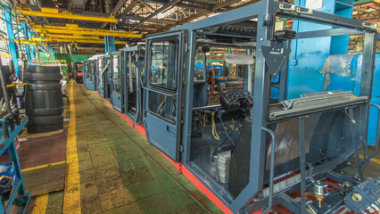 Conveyor assembly stage the body of tractor at big industrial factory timelapse