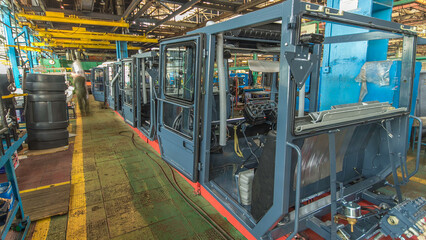 Conveyor assembly stage the body of tractor at big industrial factory timelapse