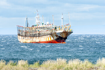 Large Industrial Squid Fishing Boat in the Strait of Magellan, Rusting Steel Hull of an International Fishing Ship in Blue Water