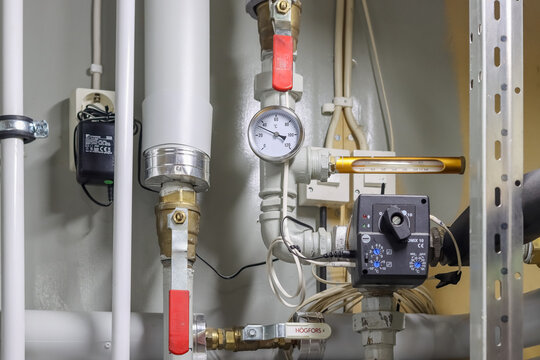 Lohja, Finland - November 18, 2022. Heating system in a boiler room of a private house. Pipes and meters related to water circulation and heating in the boiler room.