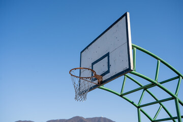 basketball hoop against blue sky © Silent Horizon Lab