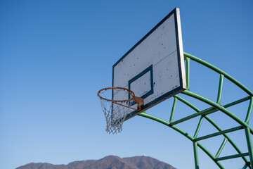 basketball hoop against blue sky © Silent Horizon Lab
