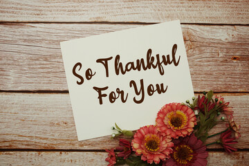 Naklejka premium So Thankful For You text with flowers bouquet on wooden background