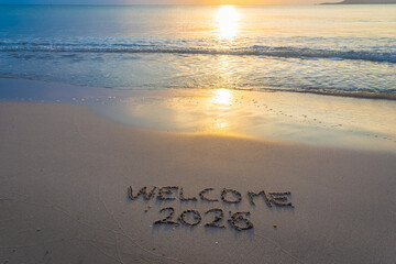 Welcome 2026 written on the sand by the sea