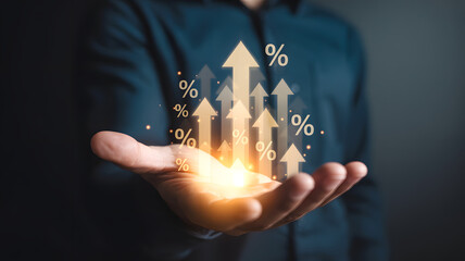 Hand holding glowing upward arrows with percentage signs symbolizing financial growth.png