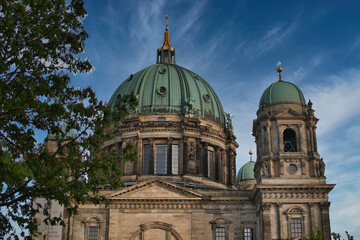 Berlin Cathedral Dome and Tower Low Angle - Dramatic low-angle view of the majestic Berliner Dom (Berlin Cathedral), showcasing its grand Baroque Revival dome and stone facade under a blue sky. © jmag.foto