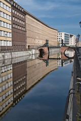 Eiserne Br&uuml;cke and Reflections in Berlin - Calm morning view of the historic Eiserne Br&uuml;cke (Iron Bridge) and old buildings perfectly reflected in the Kupfergraben canal in Berlin, Germany.