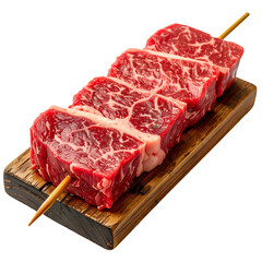 Skewered raw beef chunks, presented on a wooden board, isolated on a black background