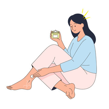 Woman applying cream to cracked heels while sitting on floor  