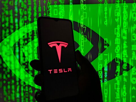 Tesla logo on a smartphone screen with a green matrix background, New York City, 21 November 2025