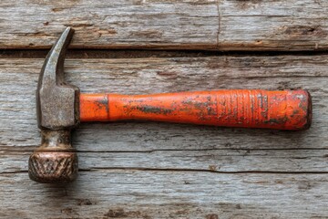 Hammer and orange screwdriver arranged on rustic wooden surface in a workshop setting for DIY projects and repairs