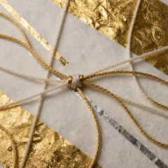 Luxury Handmade Gift Envelope Wrapped with Gold Foil Paper and Elegant String Bow Close Up
