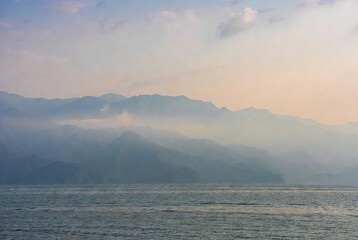 Serene hazy mountains reflecting atmospheric perspective over a peaceful