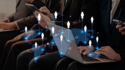 A group of business professionals interact with various devices, highlighting digital connections...